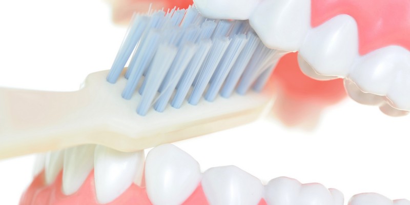 Zahnbürste zwischen Zähnen und Zahnfleisch
